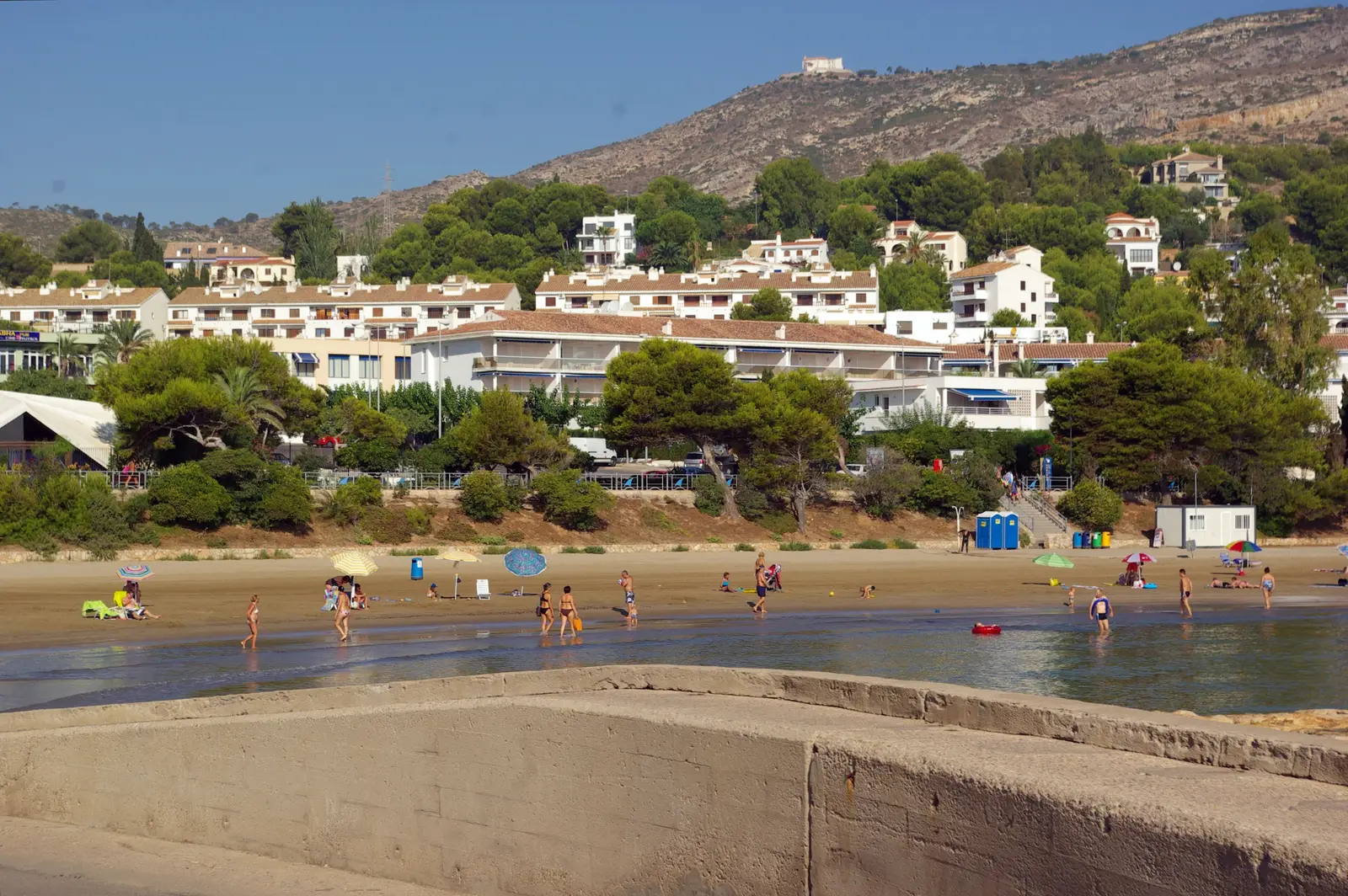 Spiaggia di Las Fuentes ad Alcossebre d'estate, con bagnanti e i monti sullo sfondo