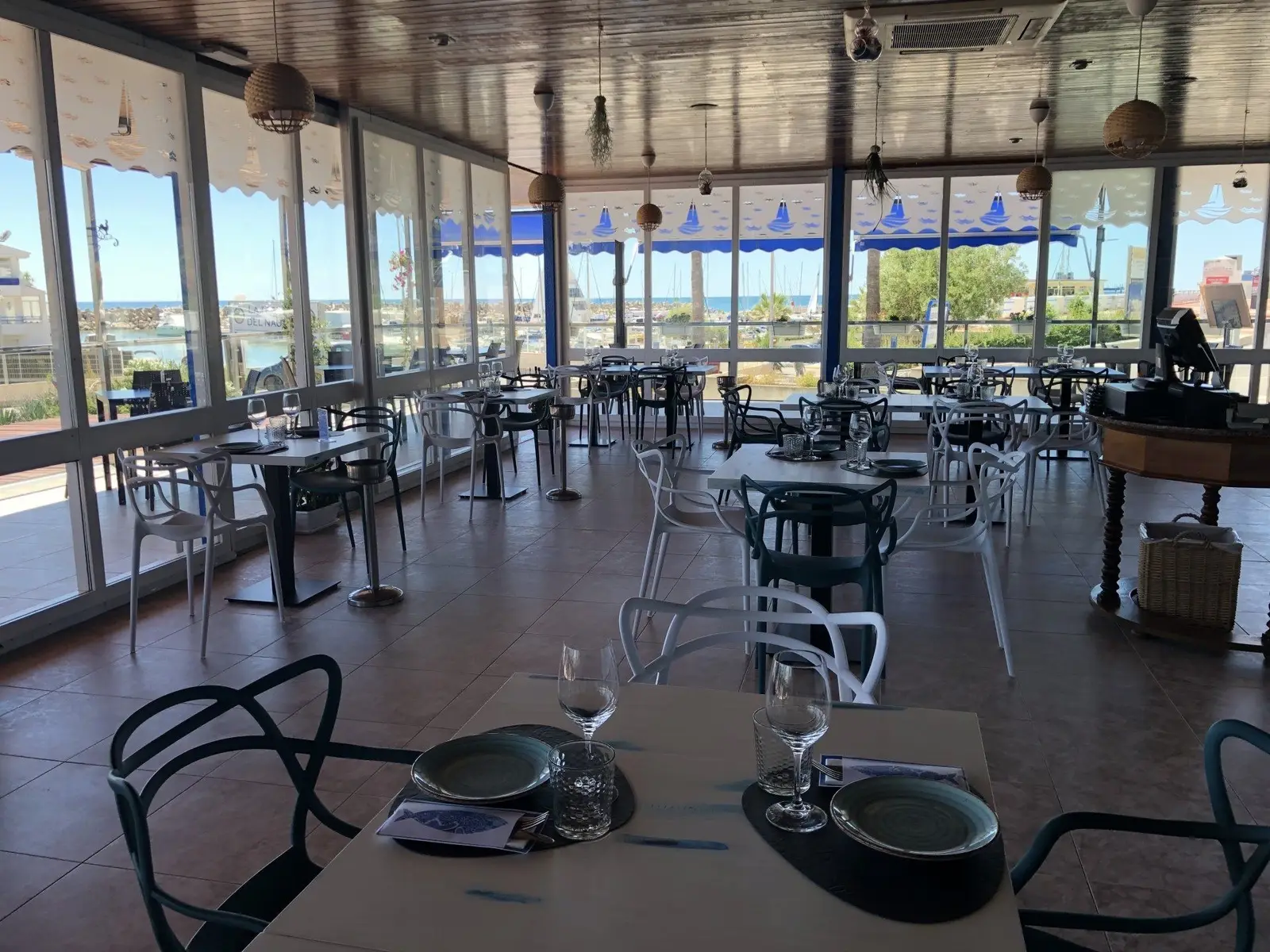 Sala acristalada del Restaurante El Náutico con vistas al mar y al puerto deportivo de Alcossebre