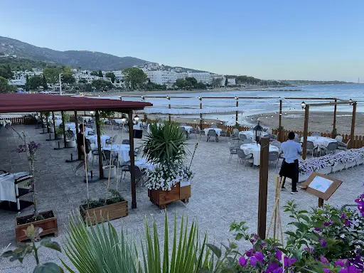 Tables de La Terraza del Náutico au bord de la plage de Las Fuentes à Alcossebre, avec la montagne au fond